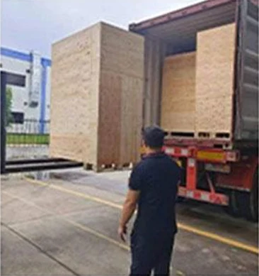 A wooden equipment crate being handled at the side of a truck